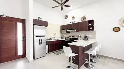 a kitchen with a counter and some chairs in it at Macaw House with private pool in Arenas Herradura in Herradura