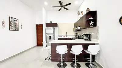 a kitchen with a counter and stools in it at Macaw House with private pool in Arenas Herradura in Herradura