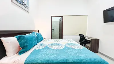 a bedroom with a bed with a blue comforter and a desk at Macaw House with private pool in Arenas Herradura in Herradura