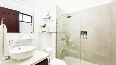 a bathroom with a sink and a toilet and a shower at Macaw House with private pool in Arenas Herradura in Herradura