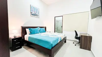 a bedroom with a bed and a desk and a chair at Macaw House with private pool in Arenas Herradura in Herradura