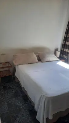 a bedroom with a large white bed with a side table at Casa Caladium in Manuel Antonio