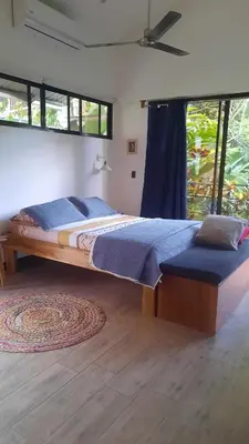 a bedroom with a large bed and a large window at Casa Caladium in Manuel Antonio