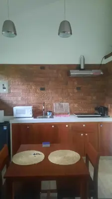 a kitchen with a wooden table and a counter at Casa Caladium in Manuel Antonio
