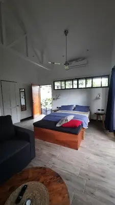 a bedroom with a large bed and a couch at Casa Caladium in Manuel Antonio