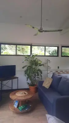 a living room with a blue couch and a table at Casa Caladium in Manuel Antonio