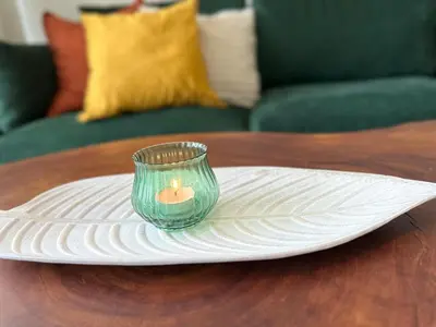 a candle in a glass on a plate on a table at Walk to Private Beach Luxury amidst Nature in Puntarenas