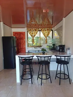 a kitchen with two bar stools and a counter at Casitas katia in Tapantí