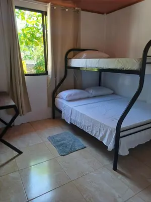 a bedroom with two bunk beds and a window at Casitas katia in Tapantí