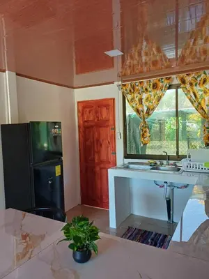 a kitchen with a sink and a black refrigerator at Casitas katia in Tapantí