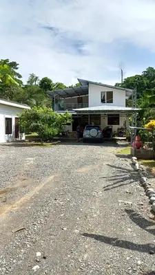a house with a gravel driveway in front of it at Casitas katia in Tapantí