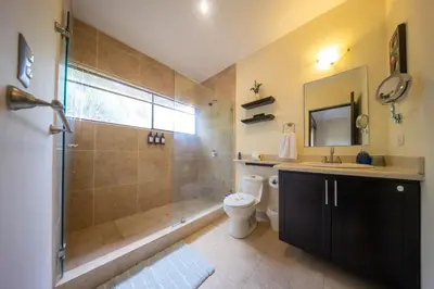 a bathroom with a shower and a toilet and a sink at The Cove Door 15 and 16 Upper & Lower Unit in Ocotal