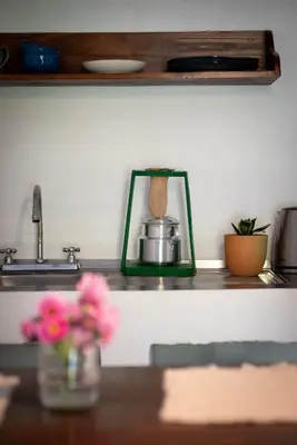 a kitchen counter with flowers in a vase on a table at Valmonte Coffee Farm in Santa María