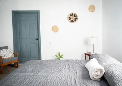 a bedroom with a bed and a blue door at Valmonte Coffee Farm in Santa María