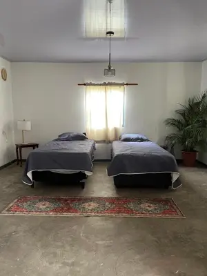 two beds in a room with a window and a rug at Valmonte Coffee Farm in Santa María