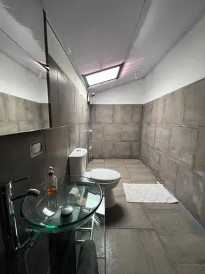 a bathroom with a toilet and a glass table at Valmonte Coffee Farm in Santa María