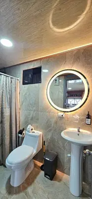 a bathroom with a toilet and a sink and a mirror at Selva with a view of the volcano, fast wifi, TV in Fortuna