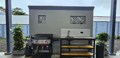 a outdoor kitchen with a grill and a stove at Selva with a view of the volcano, fast wifi, TV in Fortuna