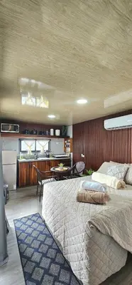 a bedroom with a large bed and a kitchen at Selva with a view of the volcano, fast wifi, TV in Fortuna