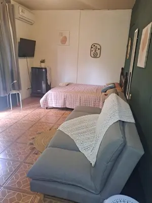 a living room with two beds and a couch at Beliz Habitación privada con baño privado in Liberia