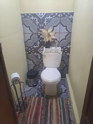 a bathroom with a toilet with a mosaic wall at Beliz Habitación privada con baño privado in Liberia