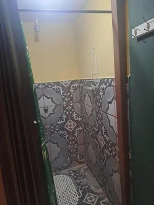 a bathroom with a shower with a tile floor at Beliz Habitación privada con baño privado in Liberia