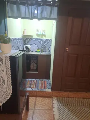 a room with a kitchen with a table with books at Beliz Habitación privada con baño privado in Liberia