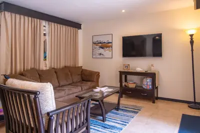a living room with a couch and a table at The Cove Door 15 Main Floor Unit in Ocotal