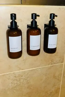 a group of three bottles of soap on a wall at The Cove Door 15 Main Floor Unit in Ocotal