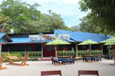 a group of tables and umbrellas in front of a building at The Cove Door 16 2 Bedroom Upper Unit in Ocotal