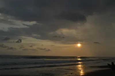 a sunset on the beach with the sun in the sky at Hostel Piramys in Tapantí