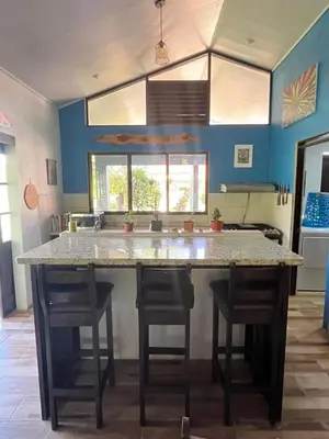 a kitchen with a large counter with two stools at Nature, Peace & Tranquility in Northern Costa Rica in Santa Rita