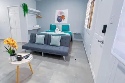 a bedroom with a blue bed and a couch at Forest apartments studio F4, walking to the beach in Jacó