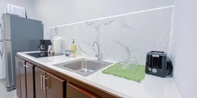 a kitchen counter with a sink and a refrigerator at Forest apartments studio F4, walking to the beach in Jacó