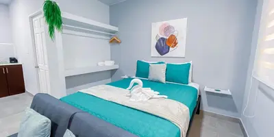 a bedroom with a green bed with a white towel on it at Forest apartments studio F4, walking to the beach in Jacó