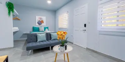 a living room with a blue couch and a table at Forest apartments studio F4, walking to the beach in Jacó