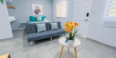 a living room with a couch and a table with flowers at Forest apartments studio F4, walking to the beach in Jacó