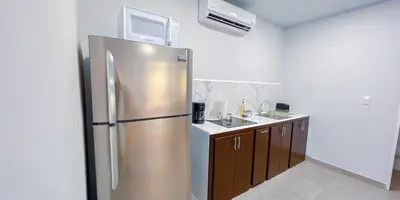 a kitchen with a stainless steel refrigerator and a sink at Forest apartments studio F4, walking to the beach in Jacó