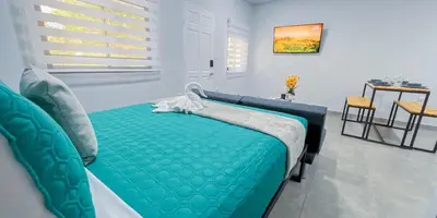 a bedroom with a green bed and a table at Forest apartments studio F4, walking to the beach in Jacó