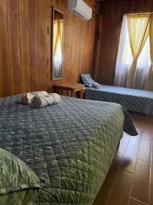 a bedroom with a large bed and a window at Cabaña Nacahome in Santa Cruz