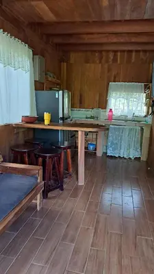 a kitchen with a large wooden table in a room at Cabaña Nacahome in Santa Cruz