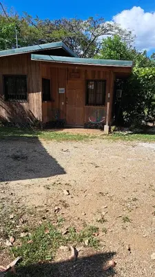 a house with a dirt yard in front of it at Cabaña Nosara in Santa Cruz