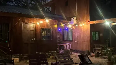 a house with lights on the side of it at night at Cabaña Nayuribe in Santa Cruz