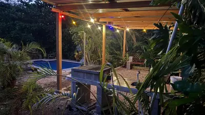 a patio with a pergola and a swimming pool at Cabaña Nayuribe in Santa Cruz