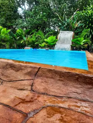 a swimming pool with a chair next to it at Iki Room with Jacuzzy in Fortuna