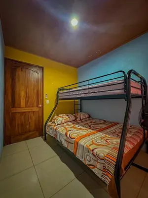 a bedroom with two bunk beds and a door at Costa Amanecer in Uvita
