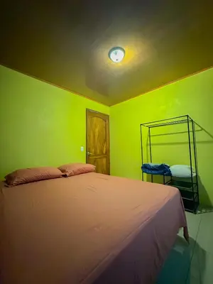a bedroom with a bed with a green wall at Costa Amanecer in Uvita