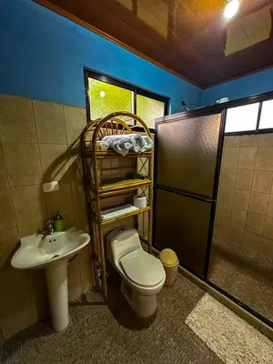 a bathroom with a toilet and a sink at Costa Amanecer in Uvita