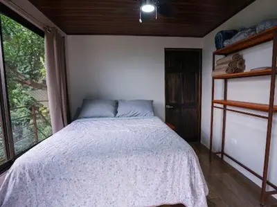 a bedroom with a bed in a room with a window at VILLA SANTA LUCÍA in front of the waterfall with a mountain view in Ceibo