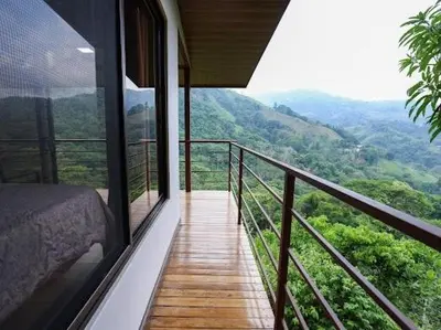 a room with a balcony with a view of the mountains at VILLA SANTA LUCÍA in front of the waterfall with a mountain view in Ceibo